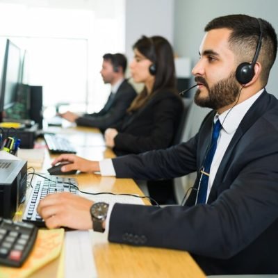 executivo-latino-atraente-oferecendo-atendimento-ao-cliente-com-fone-de-ouvido-e-oferecendo-suporte-tecnico-em-um-call-center-movimentado_662251-398